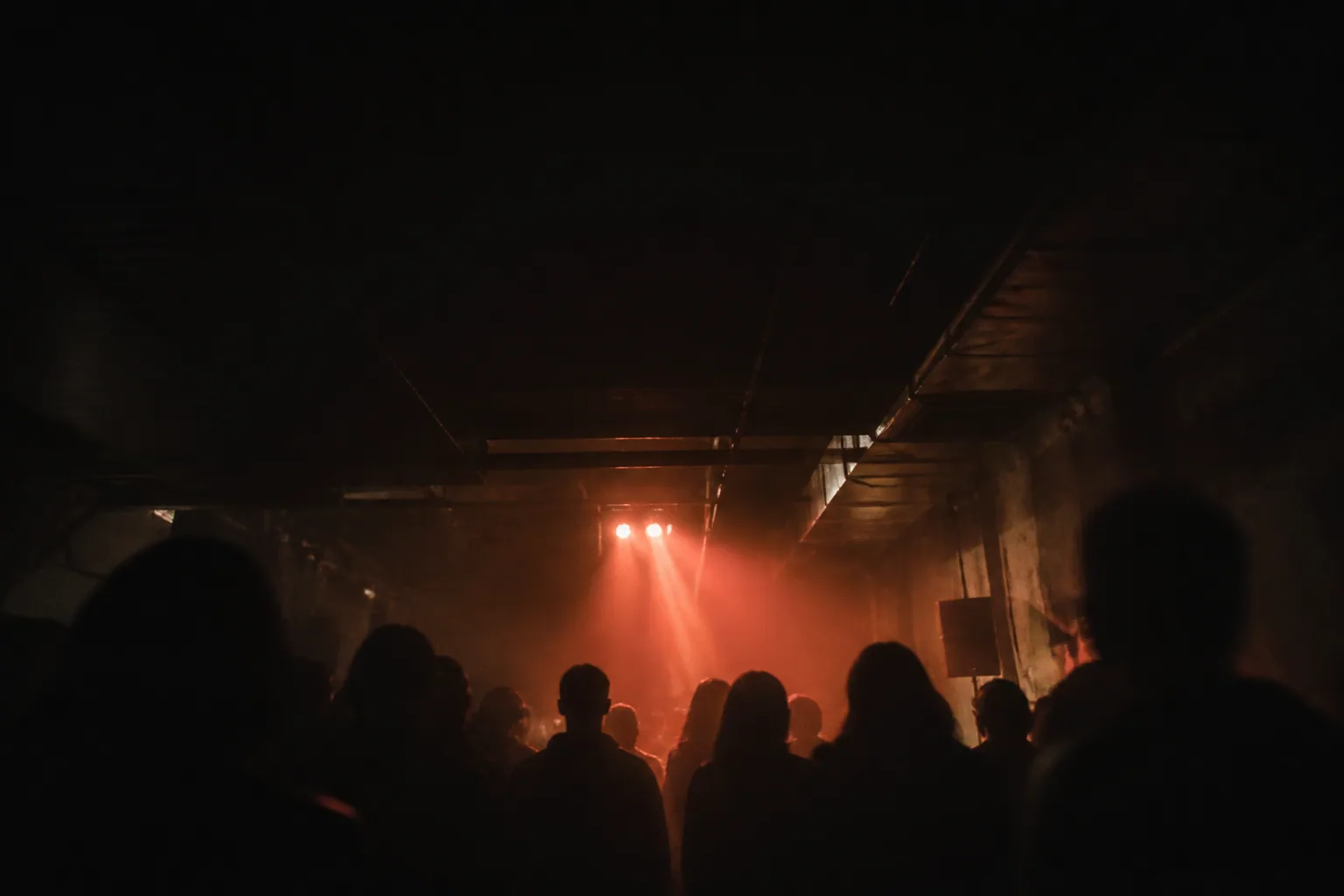 Silhouetten in einem dunklen Club unter rotem Licht