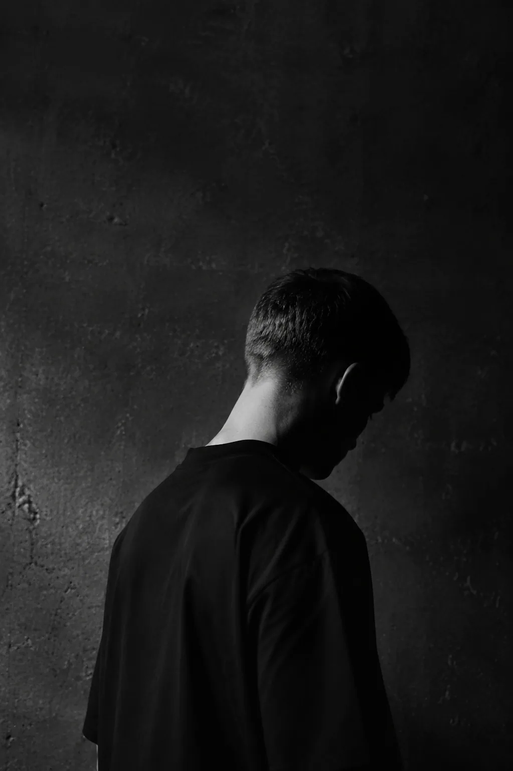 Anonyme Portraitstudie in schwarzem Hemd und silbernem Seitenlicht